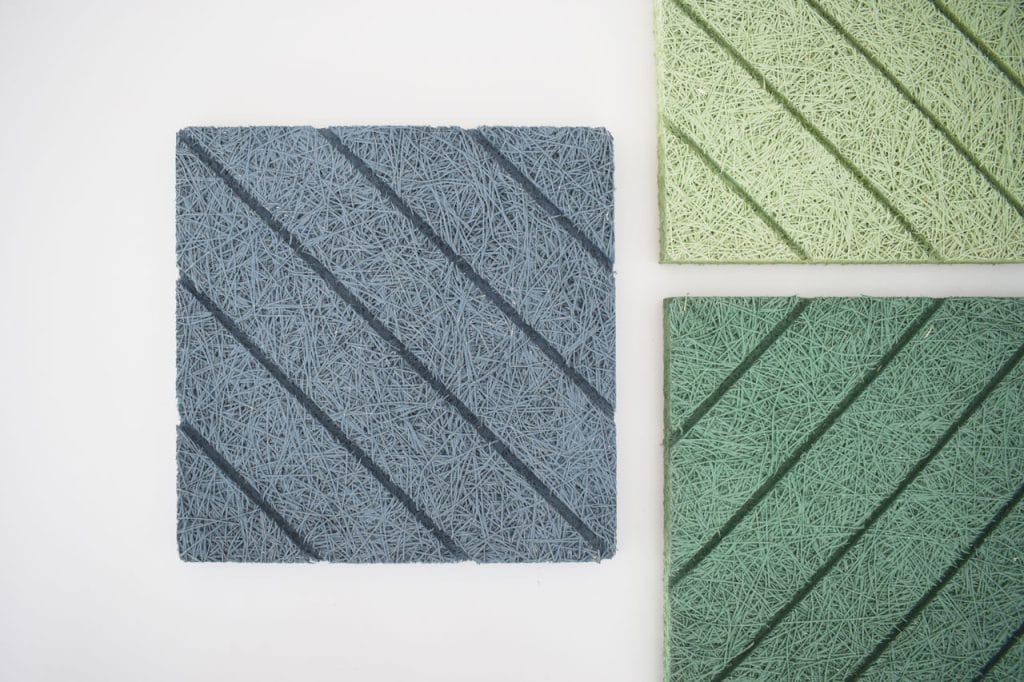 Three textured square panels with diagonal grooves are shown. One panel is blue and the other two are green, all displayed on a white background. The panels have a fibrous, woven appearance.