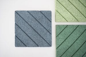 Three textured square panels with diagonal grooves are shown. One panel is blue and the other two are green, all displayed on a white background. The panels have a fibrous, woven appearance.