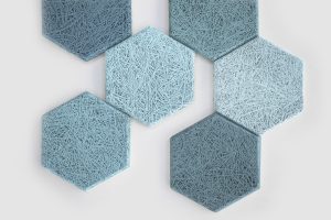 Six blue hexagonal tiles with a textured, fibrous surface are arranged on a white background. The tiles vary slightly in shade, creating a subtle gradient effect across the pattern.