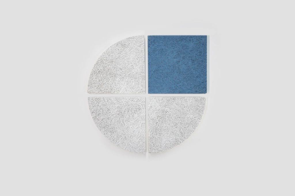 Four textured panels arranged in a circle, with three white quarter-circle pieces and one blue square piece forming the top right quadrant, all set against a light gray background.