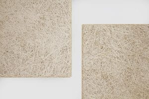 Two beige rectangular panels with textured, tangled straw-like surfaces are placed on a white background, with their corners visible and separated by negative space.