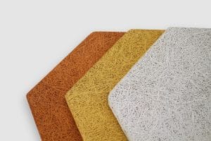 Four rectangular panels with rough, straw-like textures in orange, ochre, yellow, and white are arranged overlapping on a white background.