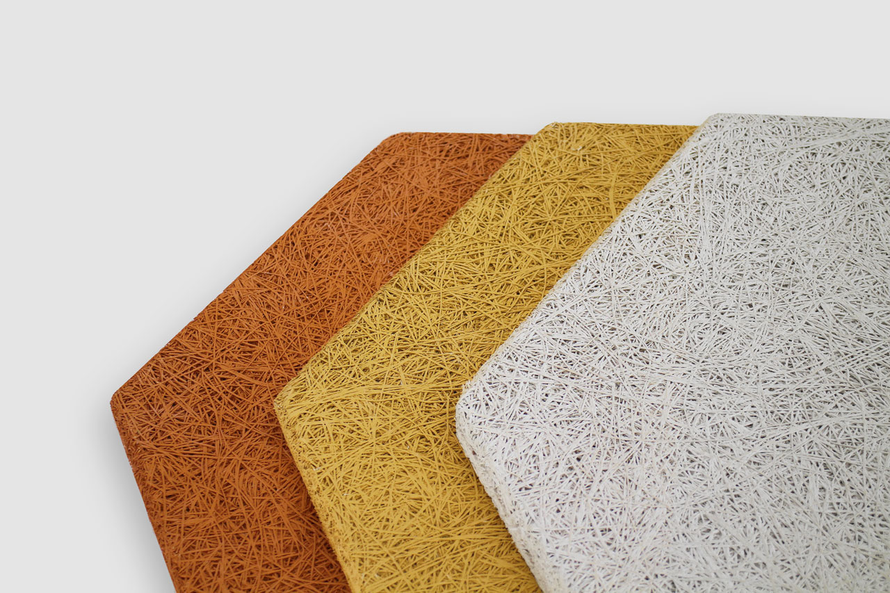Four rectangular panels with rough, straw-like textures in orange, ochre, yellow, and white are arranged overlapping on a white background.